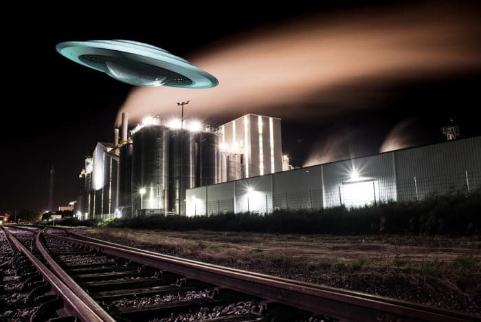 A depiction of a UFO over a power plant