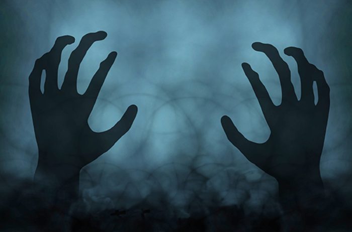 A dark misty background with a pair of ghostly hands over the top 