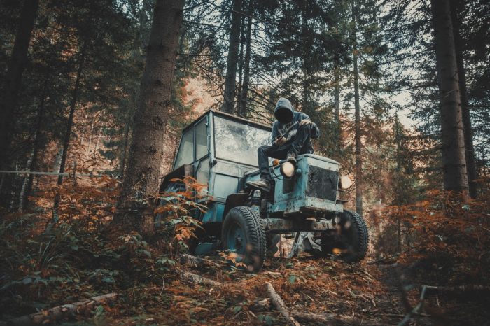 A picture of a hooded person on a tractor