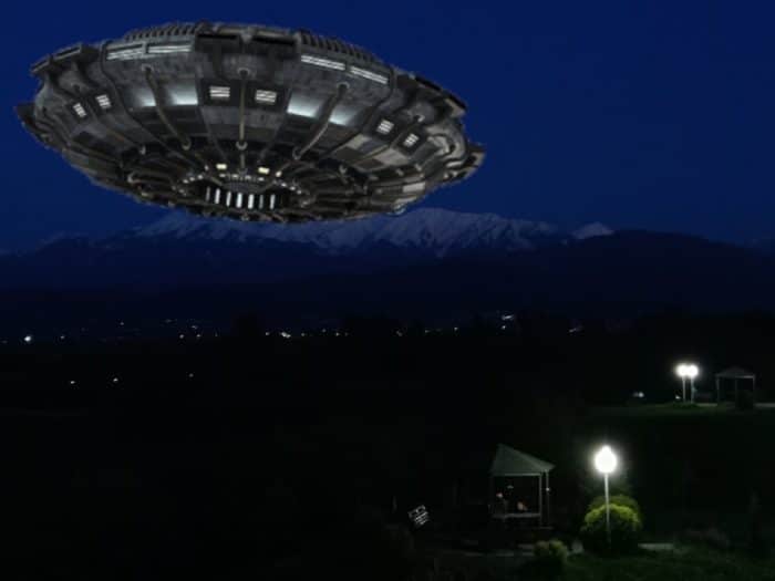 A superimposed UFO over a small mountain village at night