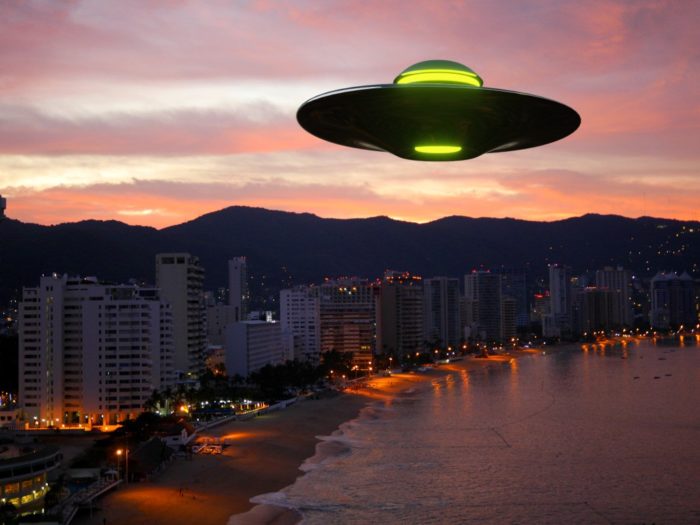 A superimposed UFO over a sunset beach community