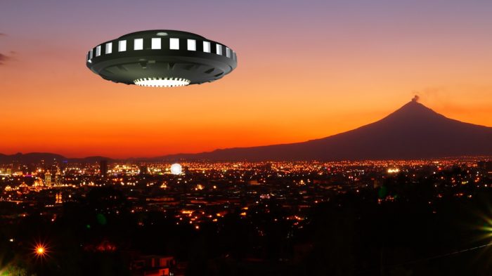 A superimposed UFO over night scene of a city