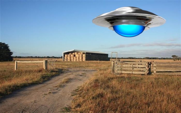 A superimposed UFO over a farm during the day