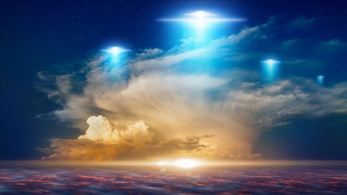 An image showing three glowing UFOs in a rich blue sky