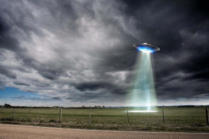 An image of a UFO hovering over a field 