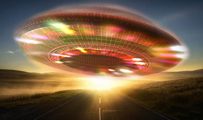 A depiction of a glowing UFO over a lonely highway at sunset