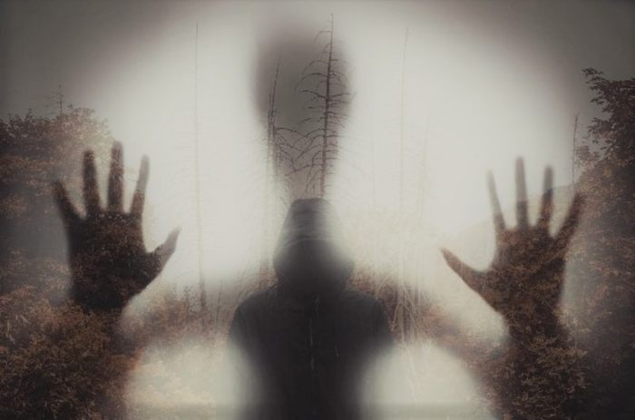 An image of hands pressed against the screen with a misty background