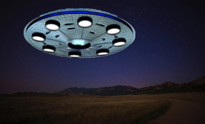 A superimposed UFO over a field at night