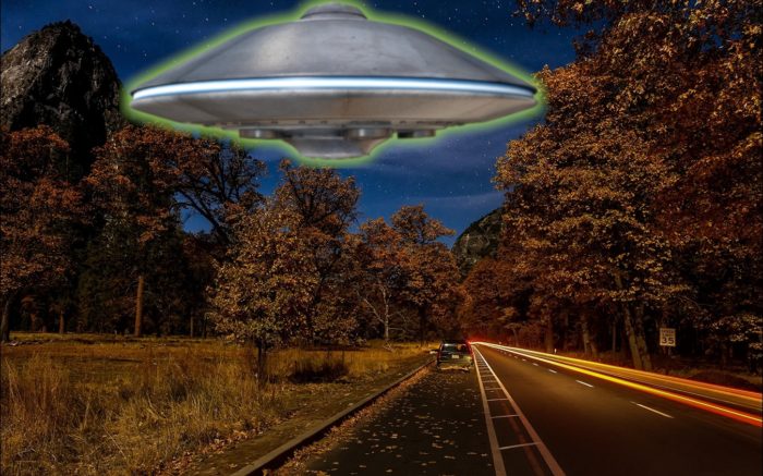 A superimposed UFO on a picture of a lonely road at night