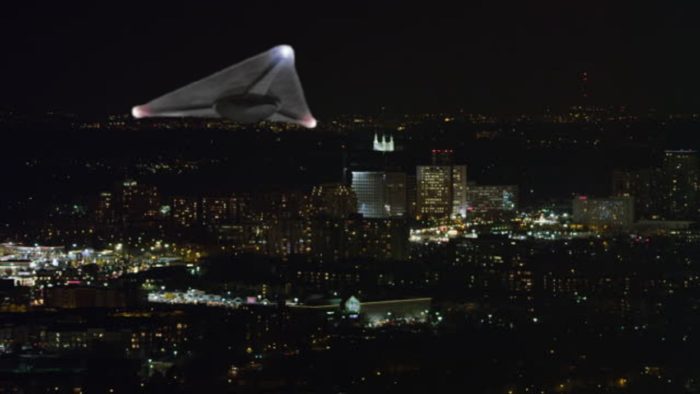 A superimposed triangular craft over a night city background