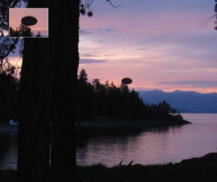 A picture showing an alleged UFO over a lake at sunset