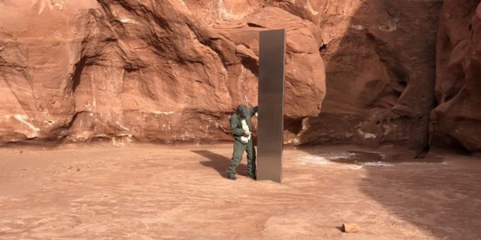 A person stood next to the Utah Monolith