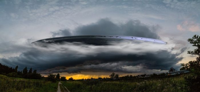 A picture of a UFO coming out of clouds