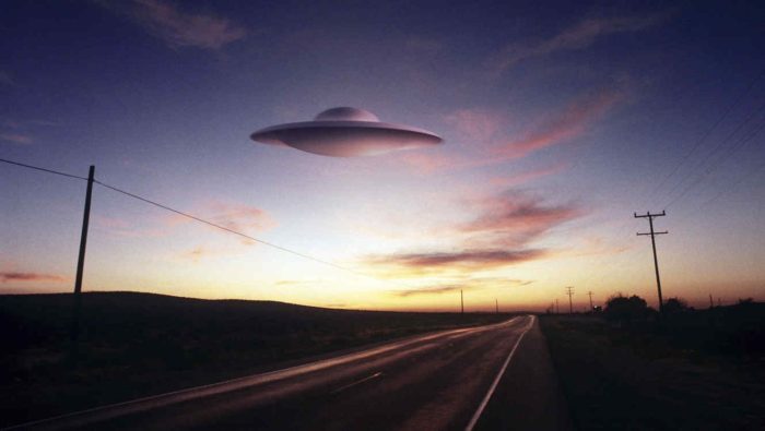 An image showing a UFO over a lonely highway