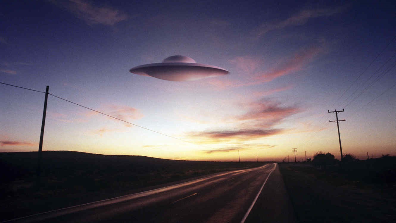 An image showing a UFO over a lonely highway.