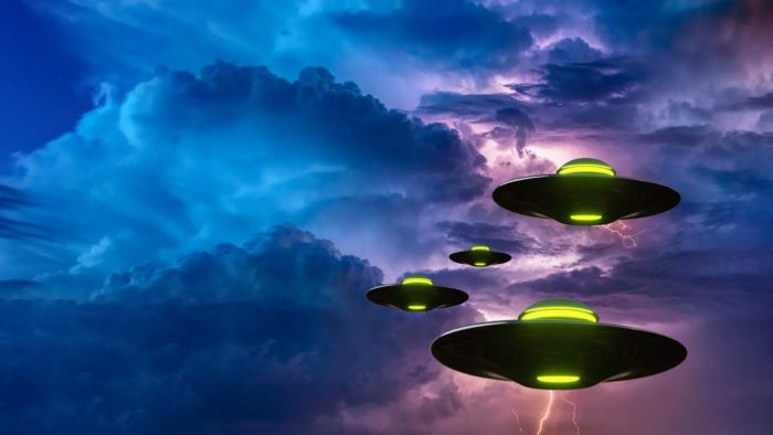 A cloudy evening sky with four superimposed UFOs over the top