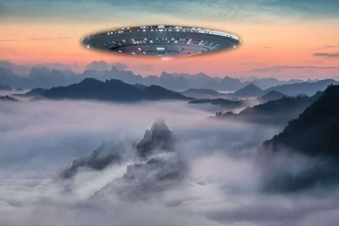 A UFO superimposed on a picture of a cloudy mountaintop 