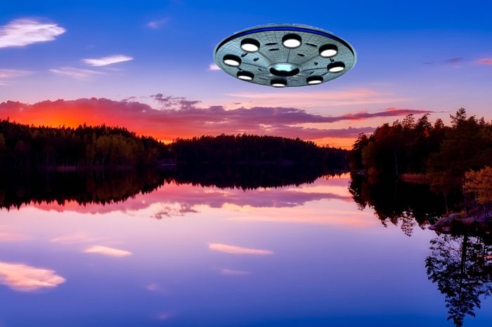 A superimposed UFO over a lake at sunset