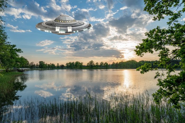 A superimposed UFO on a picture of a lake during the day