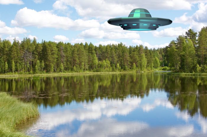 A superimposed UFO over a lake during the day