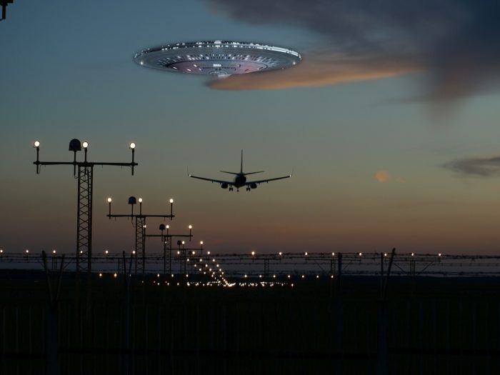 A picture of a plane flying into the distance with a superimposed UFO over the top