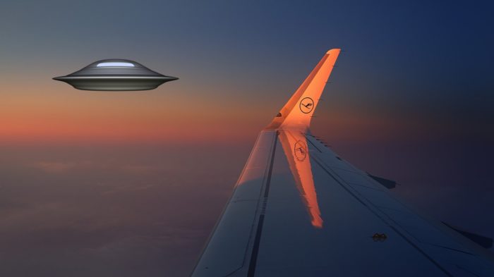 A picture of a plane's wing with a superimposed UFO at the side