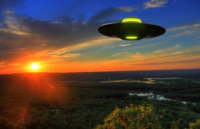 A superimposed UFO on a picture of the countryside at dawn