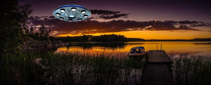 A superimposed UFO over a picture of a boating dock at sunset