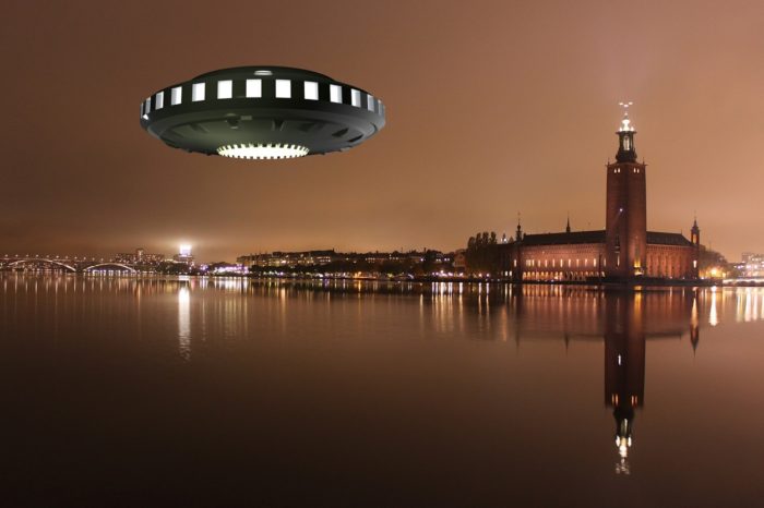 A superimposed UFO over a river with a glowing city in the background