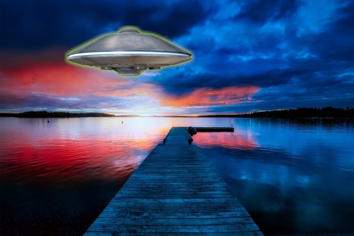 A picture of a UFO over a red and blue glowing lake