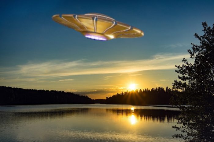 A superimposed UFO over a lake at dawn