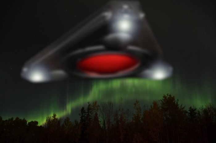 A superimposed triangular UFO over a forest with aurora sky 