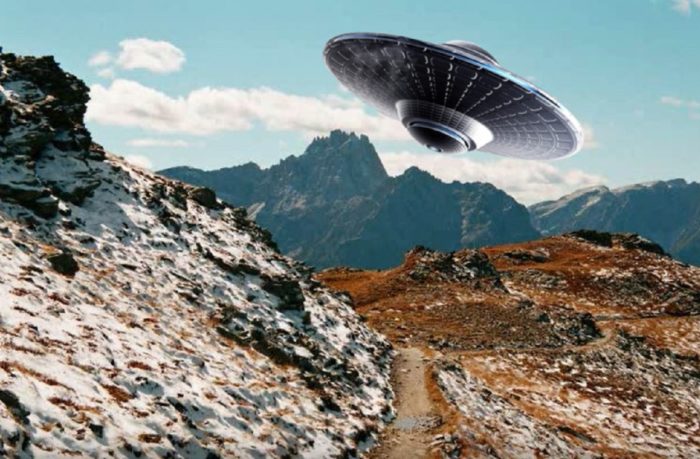 A superimposed UFO over a daytime mountain scene