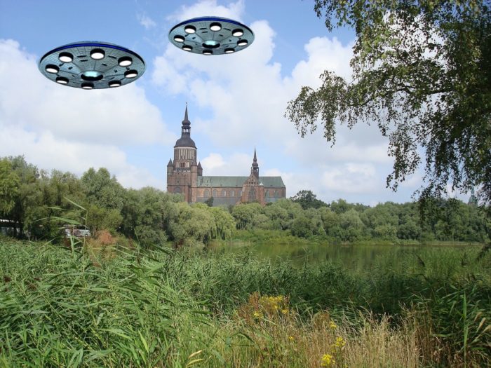 Two UFOs superimposed over a countryside picture