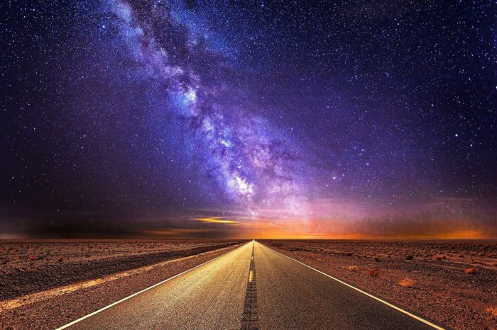 A picture of a road stretching into the distance with the Milky Way over the top