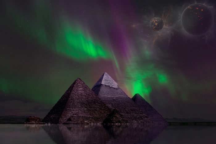 A picture of the pyramids with an aurora sky