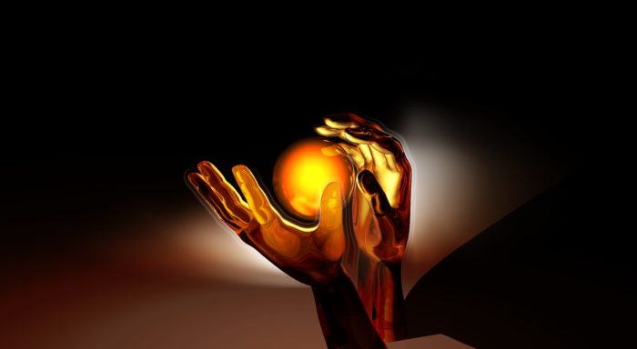 a pair of hands about to catch a glowing orb