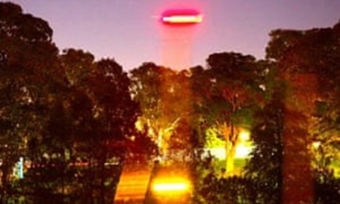 A picture showing an alleged UFO shining a light to the ground