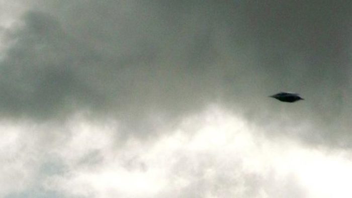 A picture showing an alleged UFO in a cloudy sky