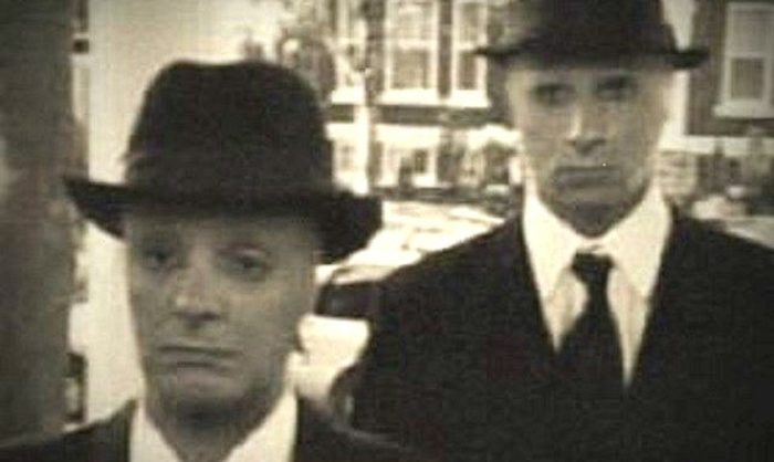 A picture showing two "Men In Black" at a doorstep