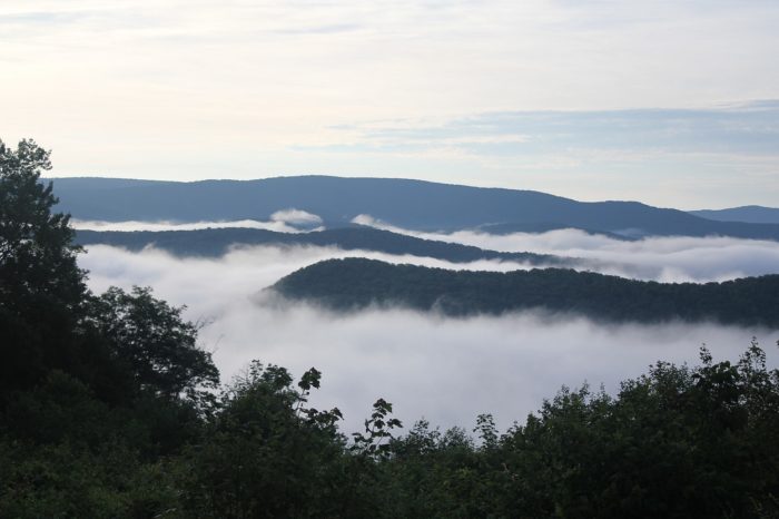 A picture of the mountain tops with rolling clouds