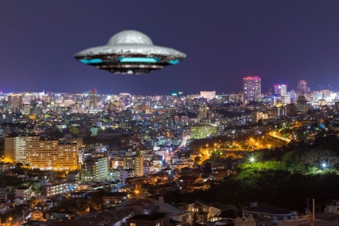 A UFO superimposed on to a glowing city at night