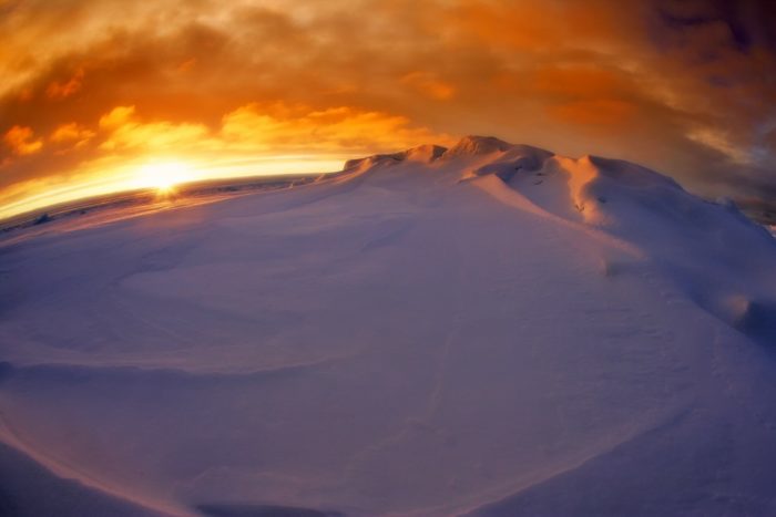 Sunset in Antarctica over snowy mountains 