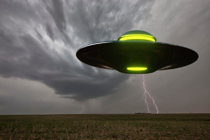 UFO over farmland in a stormy sky