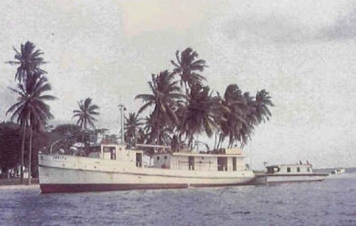 Color picture of the MV Joyita, docked near palm trees in Los Angeles