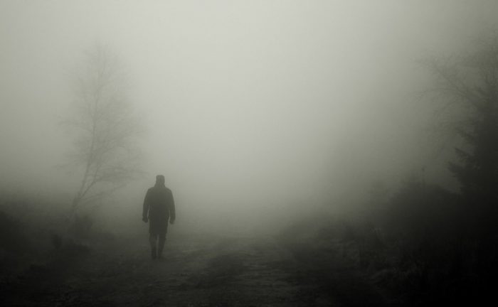 A picture of a mysterious person walking into the mist