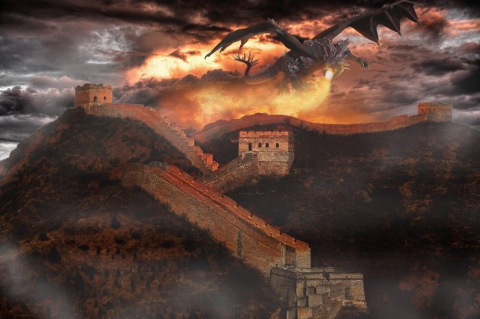 A picture of a dragon breathing fire over a castle