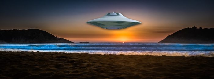 A UFO superimposed onto a sunset beach