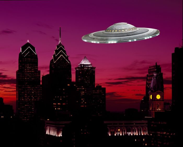 A superimposed UFO over a city at night