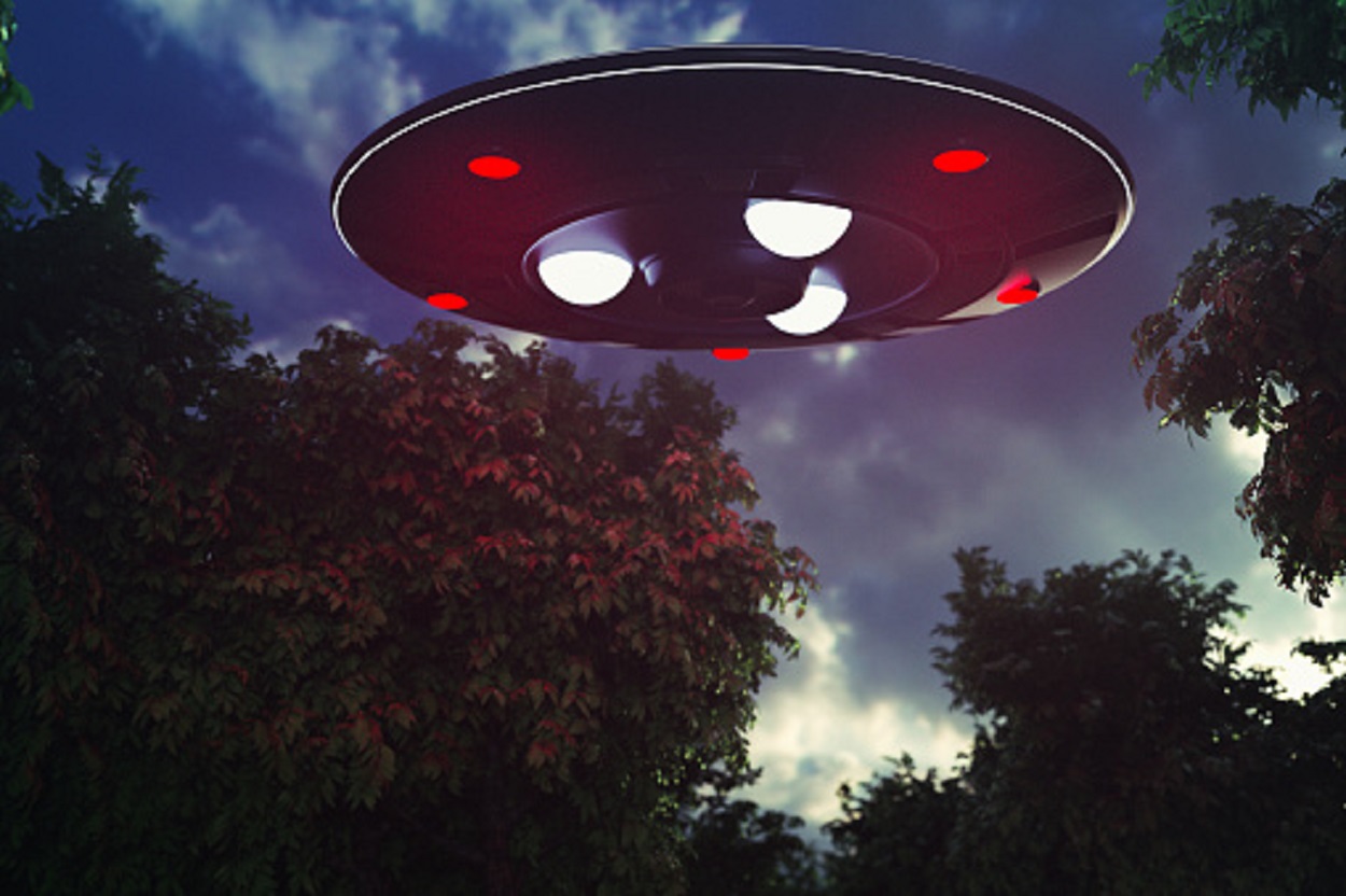 A depiction of a UFO over the trees